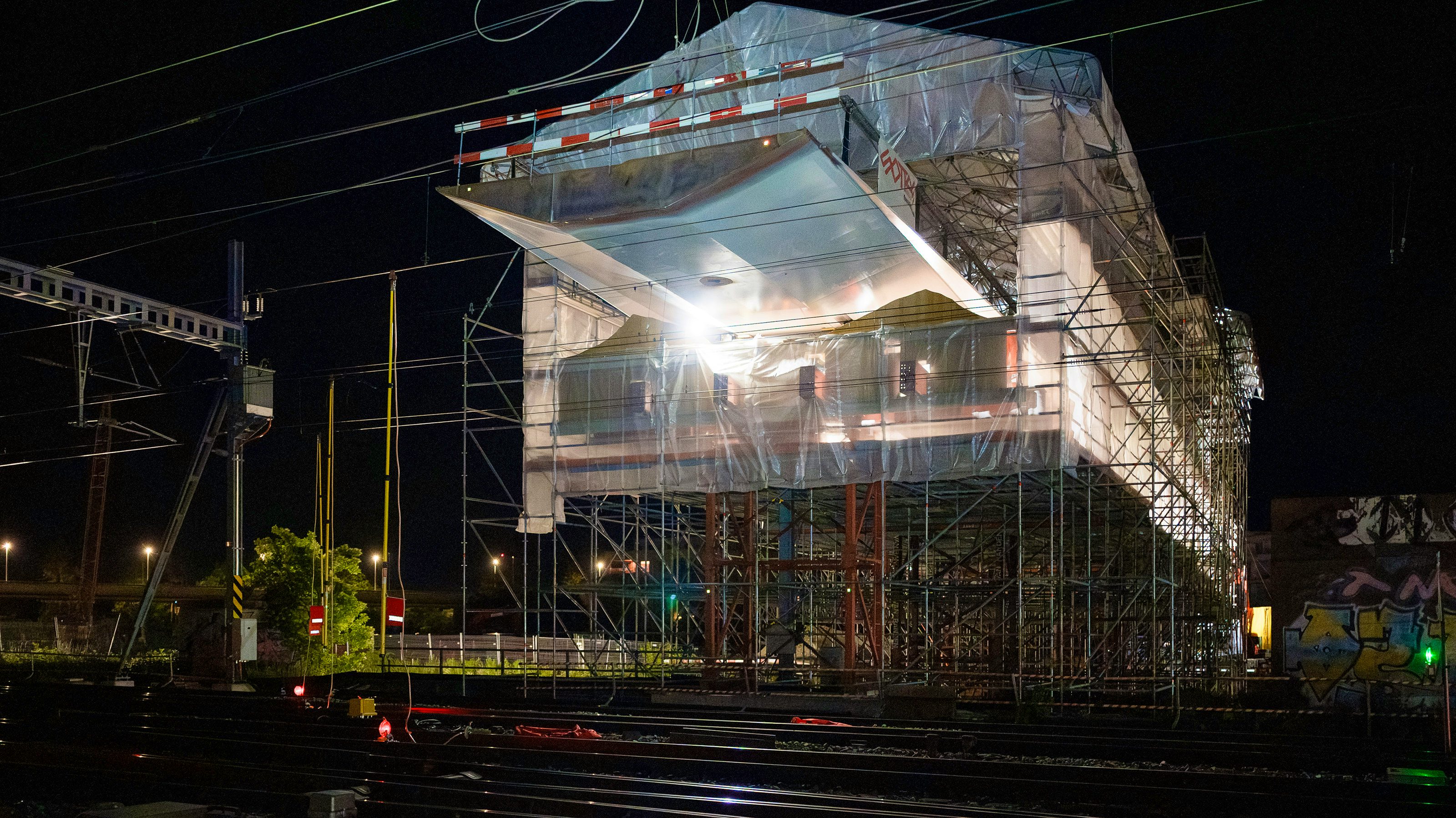 Von einer Installationsplattform aus wird die Passerelle über die Gleise geschoben.